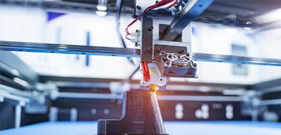 Close-up of a 3D printer creating a black prototype, showcasing advanced manufacturing technology and precision engineering.